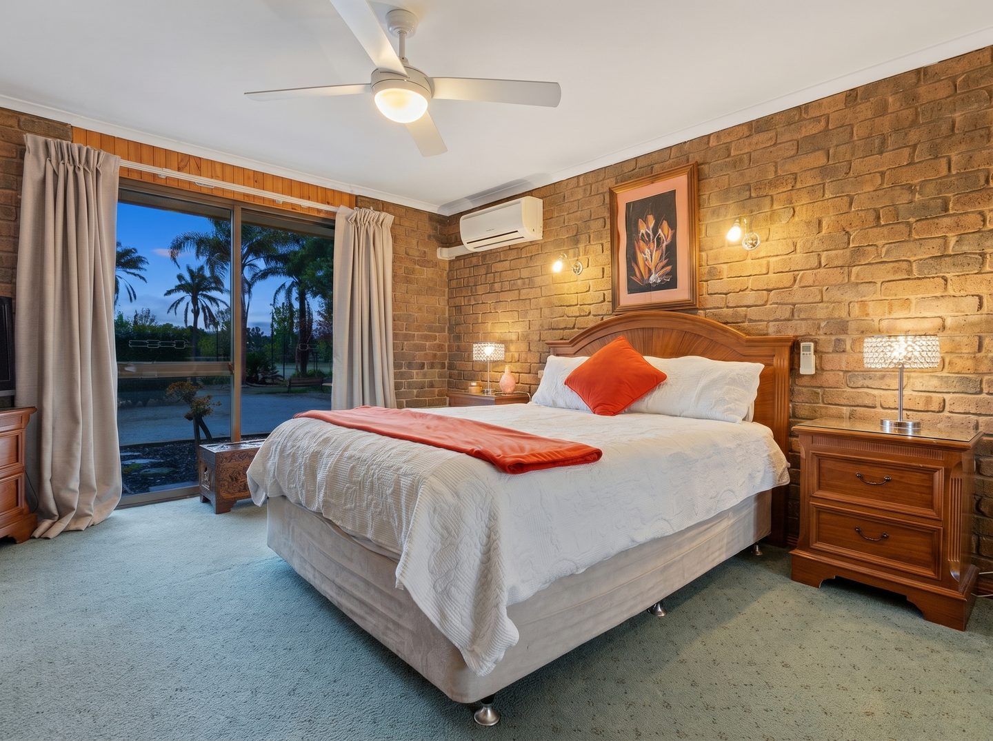 Main bedroom with exposed brick and a sliding glass door