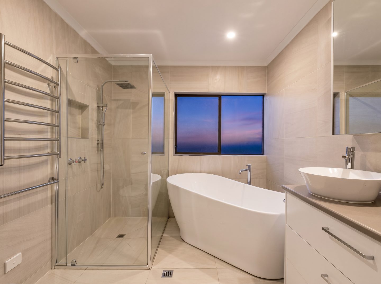 Renovated ensuite with a freestanding bath and glass shower enclosure
