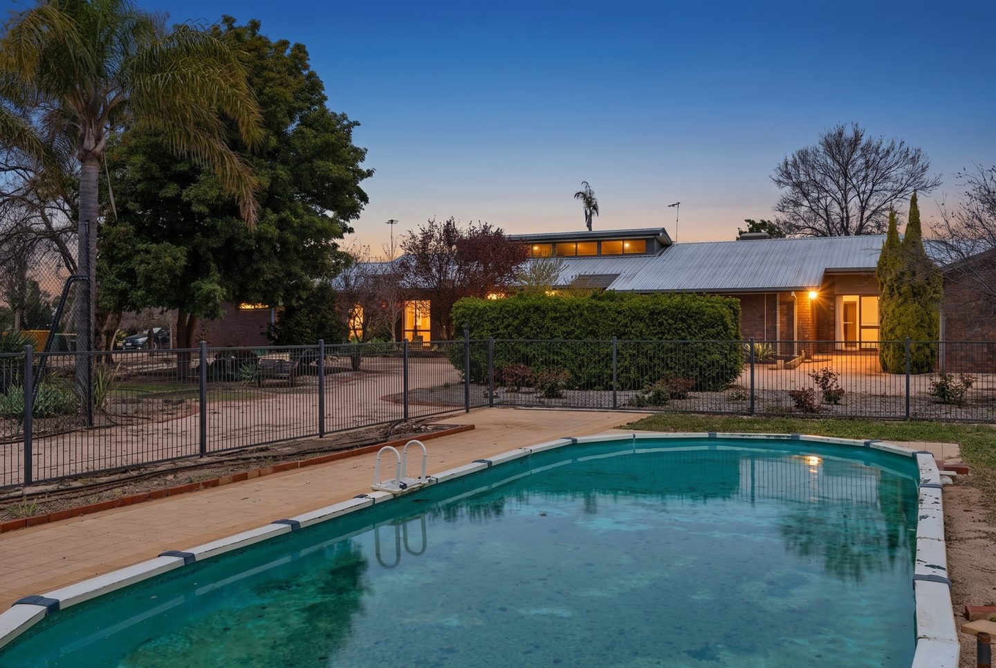 Swimming pool with the brick home beyond