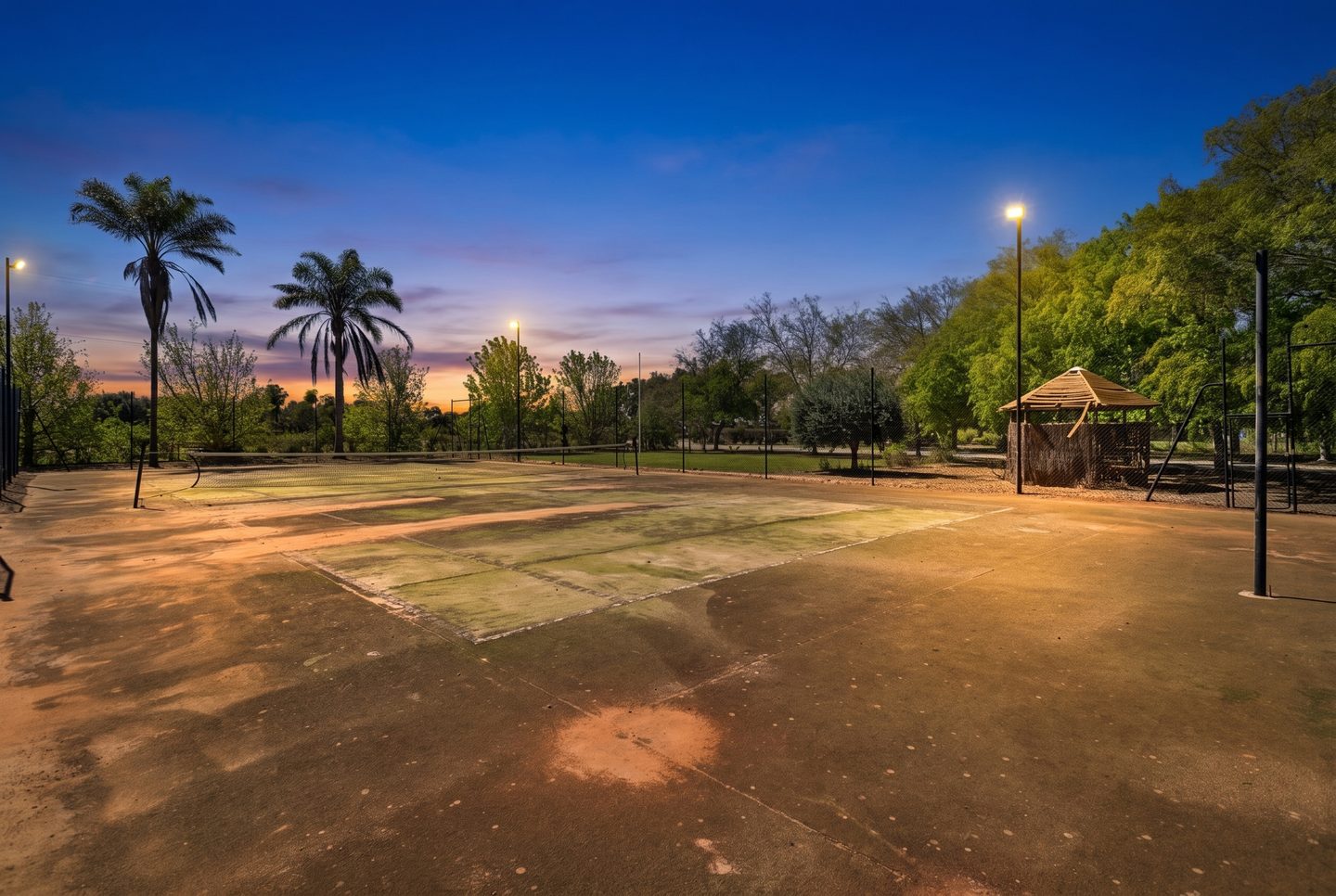 Tennis court under lights at dusk